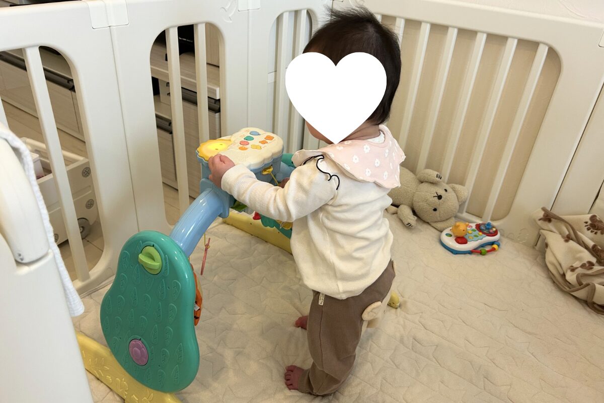 赤ちゃんがプーメリー(つかまり立ちジム)で遊んでいる様子